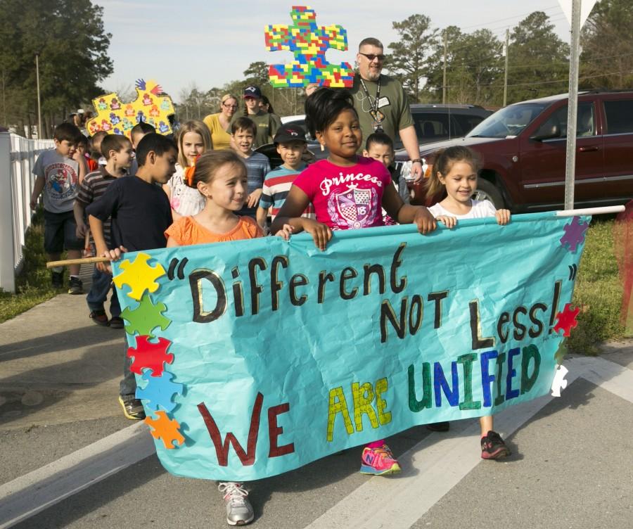 Students and family members from Johnson Primary School march, holding signs and banners in support of autism awareness aboard Marine Corps Base Camp Lejeune, Friday. According to the center for disease control and prevention, one in every 68 children in the U.S. is diagnosed with the disorder. (Photo by: Lance Cpl. Andrea Ovalle)