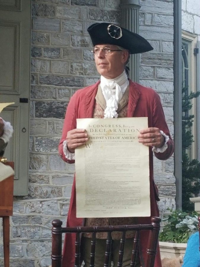 Re-enactor David Biser holds up the Declaration of Independence for the audience to see. 