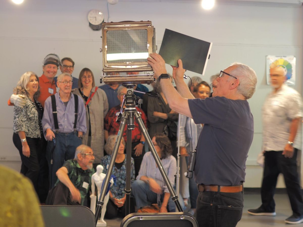 Photo taken of Mel Evans using a 4 x 5 camera to re-create a 1977 group photo.
